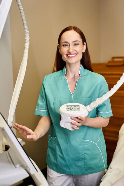 A young professional shows a dermatology procedure with advanced equipment in a clinic.