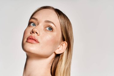 Mavi gözlü ve pürüzsüz ciltli genç bir kadın güzelliğini arttıran modaya uygun kıyafetler giyer..