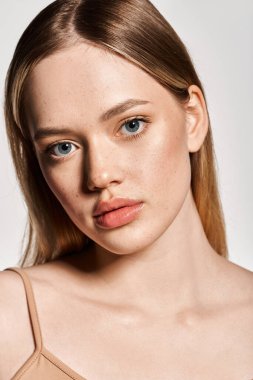 Çarpıcı özellikleri olan şık bir genç kadın zarif bir poz veriyor, moda bahar modasını somutlaştırıyor..