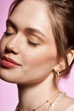 Parlak, genç bir kadın şık tarzını, yumuşak bir gülümsemeyle, rüya gibi pastel bir ortamda sergiliyor.