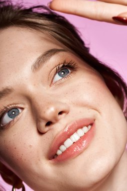 Büyüleyici özellikleri olan genç bir kadın pastel bir zemine karşı güzellik ve güven yayar..