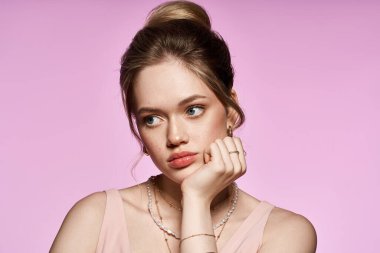 Genç bir kadın şık bahar kıyafetleri ve şık aksesuarlarıyla düşünceli bir şekilde poz verir..