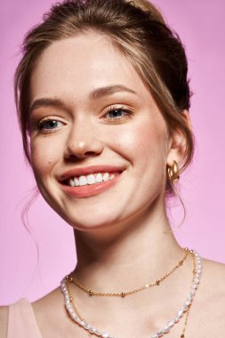 Genç bir kadın zarif takılara, şık giysilere ve gülümsemeye sahip..