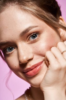 Güzel genç bir kadın, canlı pembe bir arka plana karşı zarafetini sergiliyor..