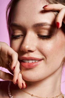 Güzel genç bir kadın şık bahar kıyafetlerini zarif bir gülümsemeyle sergiliyor..