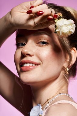 Genç bir kadın zarif kıyafetini narin bir çiçekle sergiliyor..