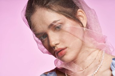 Genç bir kadın şık bir stil ve zarif bir peçeyle zarafet saçar, canlı bir özü yakalar..