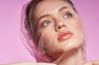 Genç ve güzel bir kadın zarif poz veriyor, zarif bir peçeyle süslenmiş şık bir bahar tarzı sergiliyor..