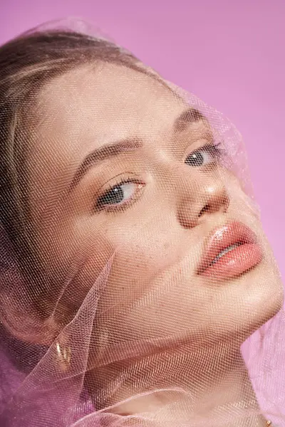 Genç bir kadın zarif bir ifade ve şık bir tül örtüsüyle zarafet yayar, bahar için mükemmeldir..