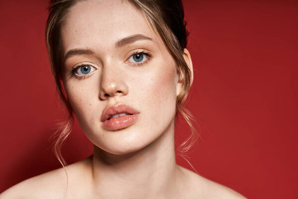 Потрясающая молодая женщина демонстрирует свою красоту голубыми глазами и безупречной кожей, проявляя элегантность.