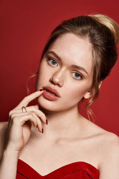 Очаровательная молодая женщина излучает элегантность в своем стильном красном наряде и безупречном макияже.