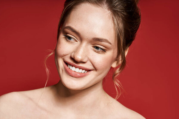 Молодая, красивая женщина с сияющей улыбкой наслаждается теплым весенним солнечным светом.