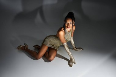 Genç ve güzel bir kadın şık giyiniyor. İçerde şık bir duruş sergiliyor..