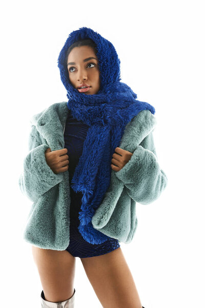 Элегантная молодая женщина демонстрирует модный наряд со стильной верхней одеждой в шикарной обстановке.