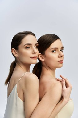 İki güzel kız kardeş güçlü bağlarını gösterirken yan yana zarifçe poz veriyorlar..