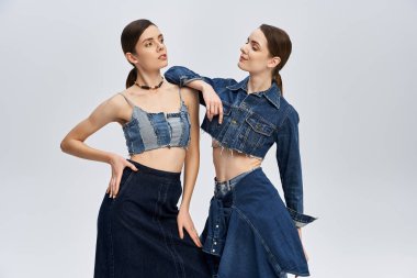 İkizler eşsiz kot tarzlarını sergiliyorlar, güzel bağlarını vurguluyorlar..