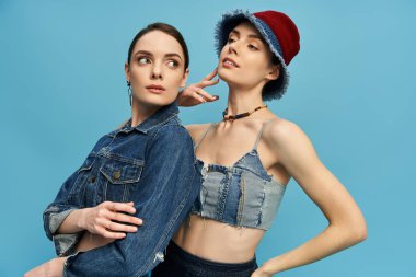 İki güzel ikiz birlikte poz veriyor, eşsiz tarzlarını ve komik ifadelerini sergiliyorlar..