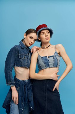 İki güzel ikiz kardeş modaya uygun kot kıyafetlerle poz veriyor, özgüven ve tarz yayıyorlar..