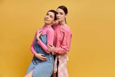 İki güzel ikiz kardeş, eşsiz moda anlayışlarını gösterirken, aynı zamanda gülümsüyorlar..