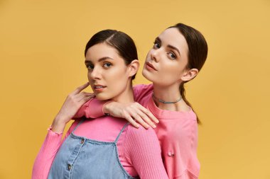 İki güzel ikiz şık poz veriyor, ışık saçan cazibe ve bağlantı parlak bir ortamda..