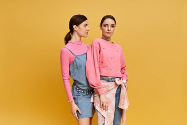 İki güzel kız kardeş hararetli moda seçimleri sergilerken kardeşçe bir bağ ve zarafet sergiliyorlar..