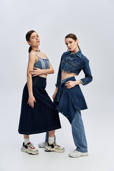 Twins pose confidently in trendy denim attire, celebrating their unique styles and beauty.