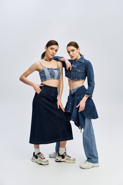 Twin sisters express their fashion sense with coordinated denim outfits, radiating beauty.