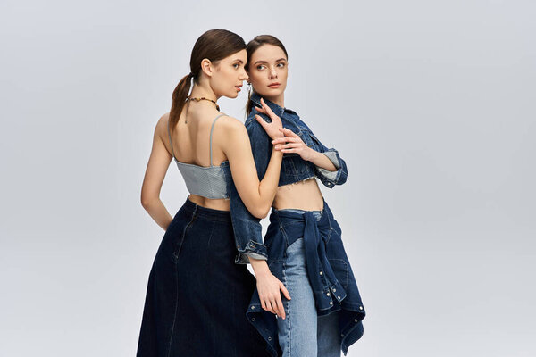 Two beautiful sisters showcase their fashion sense in contemporary attire while striking a pose.