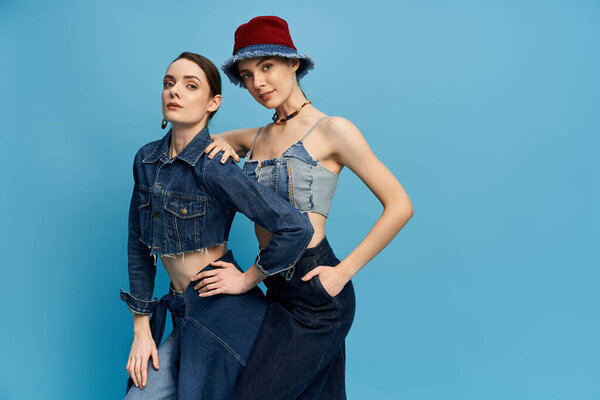 Two beautiful sisters pose confidently in trendy denim outfits, exuding charm and elegance.