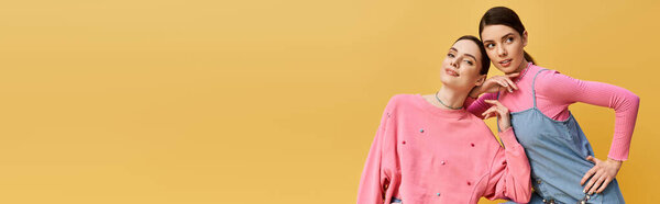 Two pretty twin sisters share a joyful moment, showcasing their fashion sense in a bright setting.