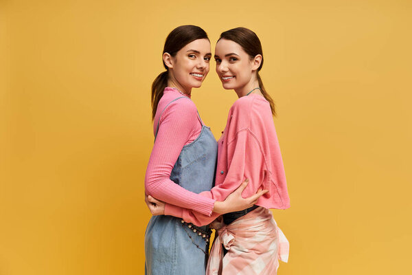 Две симпатичные сестры-близнецы тепло улыбаются, демонстрируя свою связь в яркой, веселой обстановке.