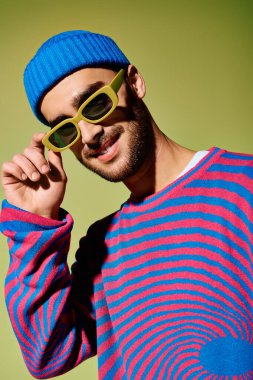 Young man showcases his unique fashion sense with stylish sunglasses and colorful attire. clipart