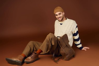 Yakışıklı bir genç adam, kendine has tarzının altını çizerek şık bir kış elbisesi modelliyor..