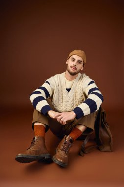 Yakışıklı genç adam benzersiz moda anlayışını modern stüdyo ortamında sergiliyor..
