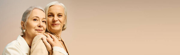 Две уверенные в себе женщины разделяют радость, излучая любовь через свои стильные наряды.