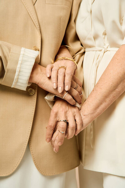 Two stylish women demonstrate their love as they hold hands, embodying romance and connection.