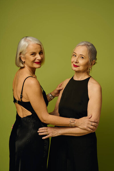 Две стильные женщины разделяют теплые объятия, демонстрируя свою любовь и элегантный выбор моды.