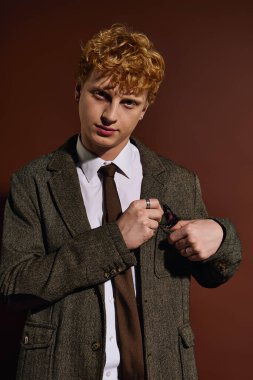 A fashionable young man with curly hair prepares confidently, showcasing his unique style and charm. clipart