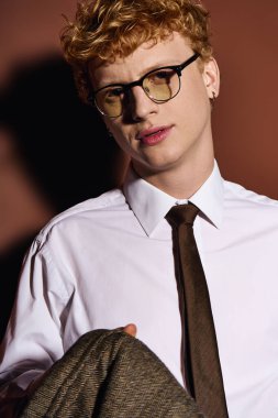 Şık bir genç adam çarpıcı stili ve moda gözlükleriyle kendine güveni yayarak büyülüyor..