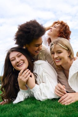 Four stylish friends laugh together outdoors, embracing natures beauty. clipart