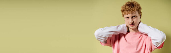 A young handsome man is striking a fashionable pose, expressing trendy style and confidence.