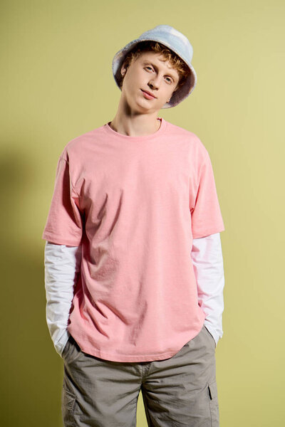 A confident young man in a pink shirt and bucket hat embodies modern street fashion.