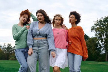 Dört modaya uygun kadın doğada moda bahar kıyafetleri modelliği yaparken güven yayıyor..