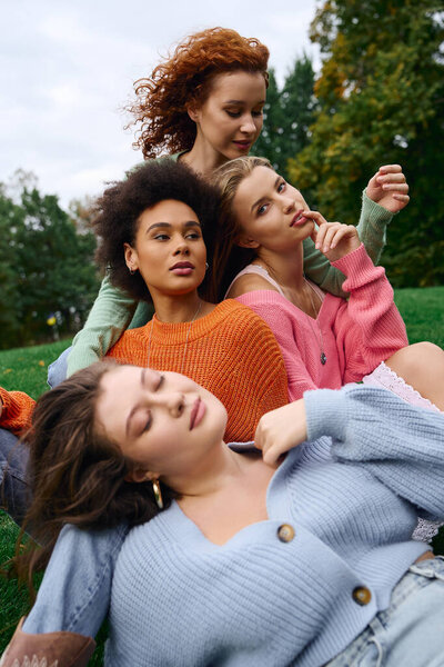 Four confident women enjoy a sunny spring day outdoors while showcasing stylish outfits.