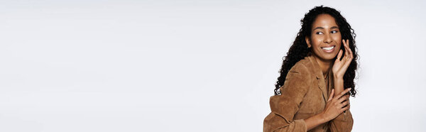 A confident African American woman in stylish attire showcases her exquisite jewelry.