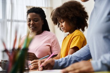 İki kadın ve kızları birbirlerine bağlanırken neşeyle birlikte sanat yaratıyorlar..