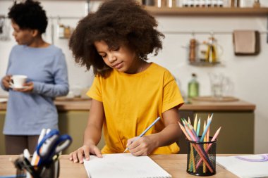 Neşeli bir anne, kızı çizim konusunda yaratıcı davranırken kaliteli vakit geçirmekten hoşlanır..