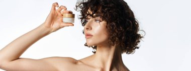 Woman with curly hair holds skincare jar gracefully, highlighting her radiant beauty and glow. clipart