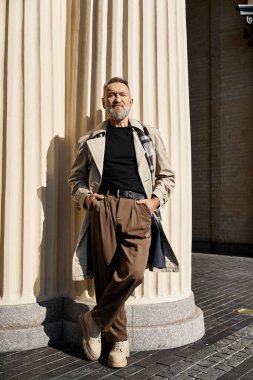 Son sınıf öğrencisi modern moda anlayışını sergileyerek büyük bir sütuna yaslanıyor..