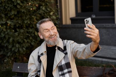 Şık giyinmiş yakışıklı bir son sınıf öğrencisi selfie çekerken neşeli bir anı yakalıyor..
